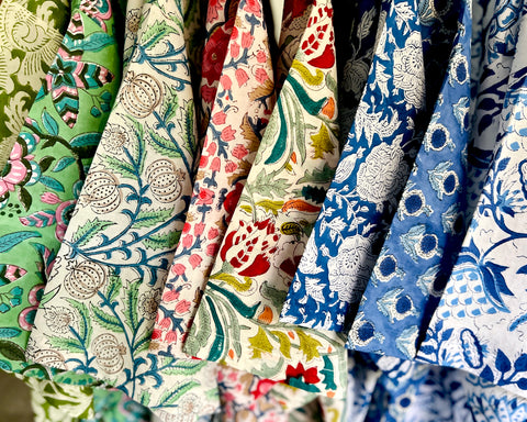 Close up of various floral block print kimono sleeves hanging from clothes rail