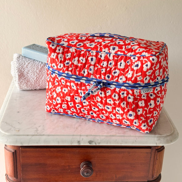 Quilted cotton vanity case washbag made from orange, blue and white 'Antibes' floral trimmed with blue and white polka dot binding.