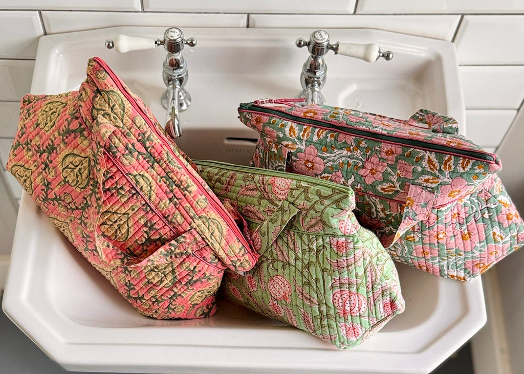 vanity wash bag in black, red and blue arts and craft style floral print with contrast trim and quilt stitching