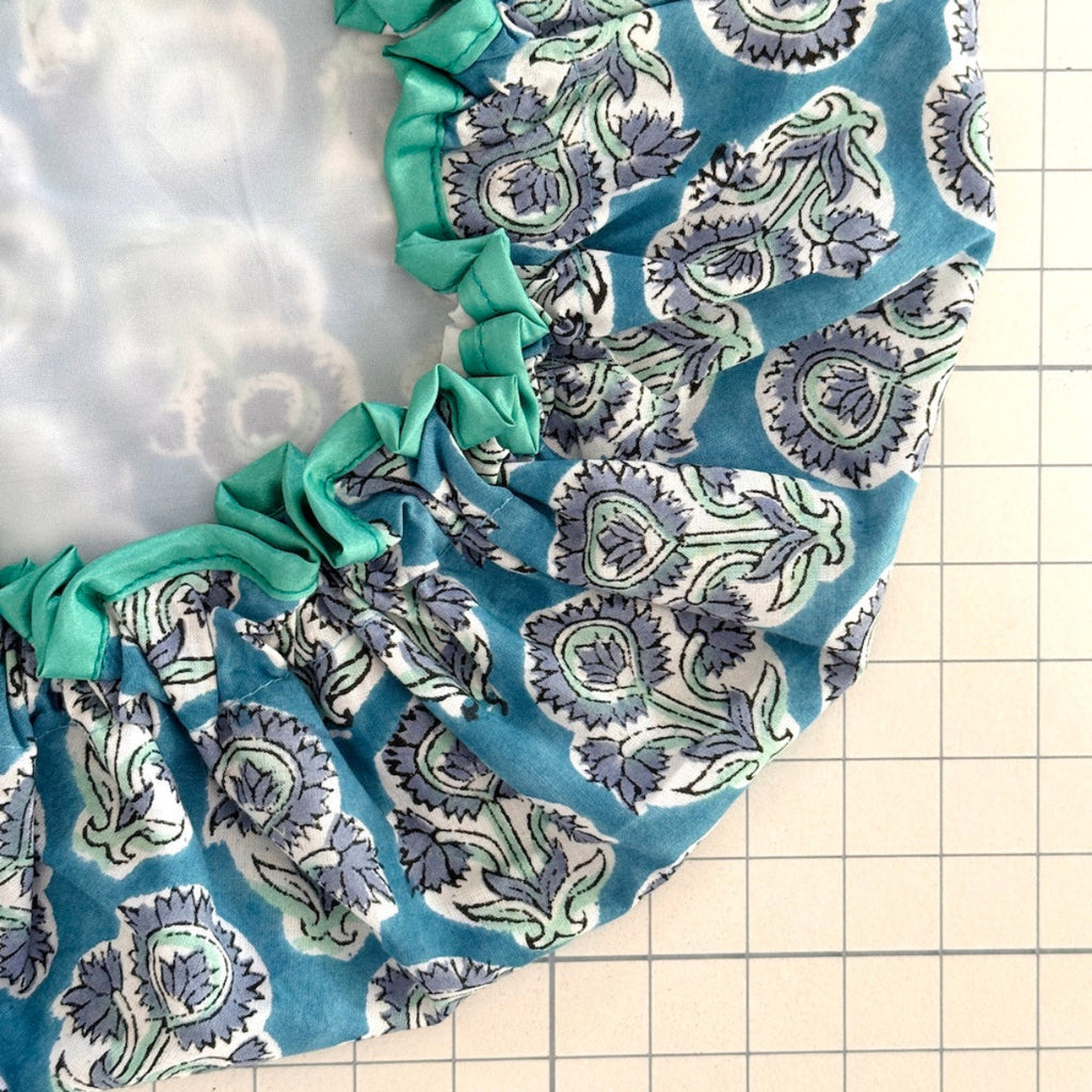 close up of blue floral 'Auricla' bat hat with white water resistant lining