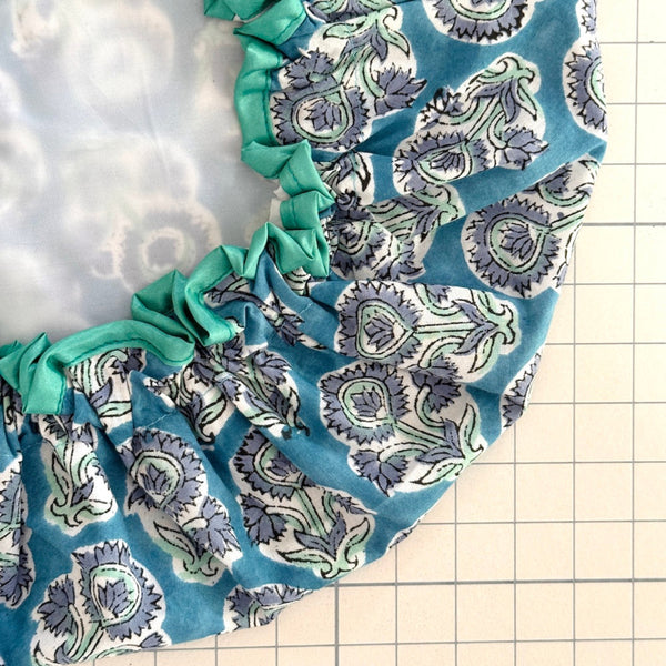 close up of blue floral 'Auricla' bat hat with white water resistant lining