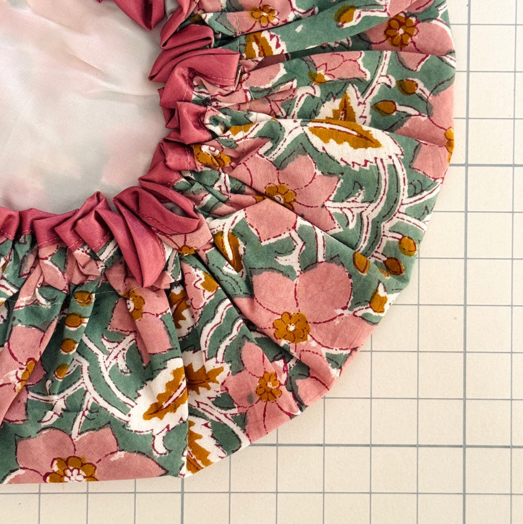 Close up of green, pink and white floral print bath hat