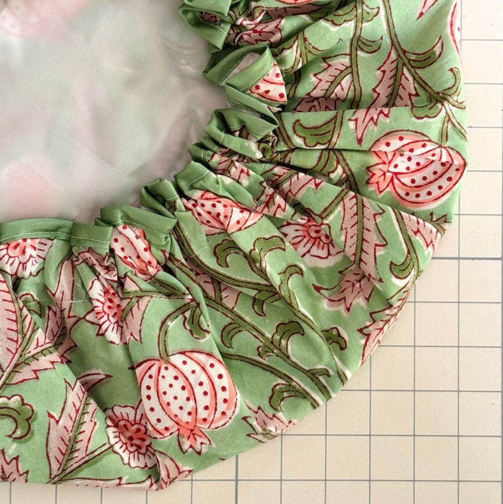 close up of floral print bath hat made from green and pink winding floral