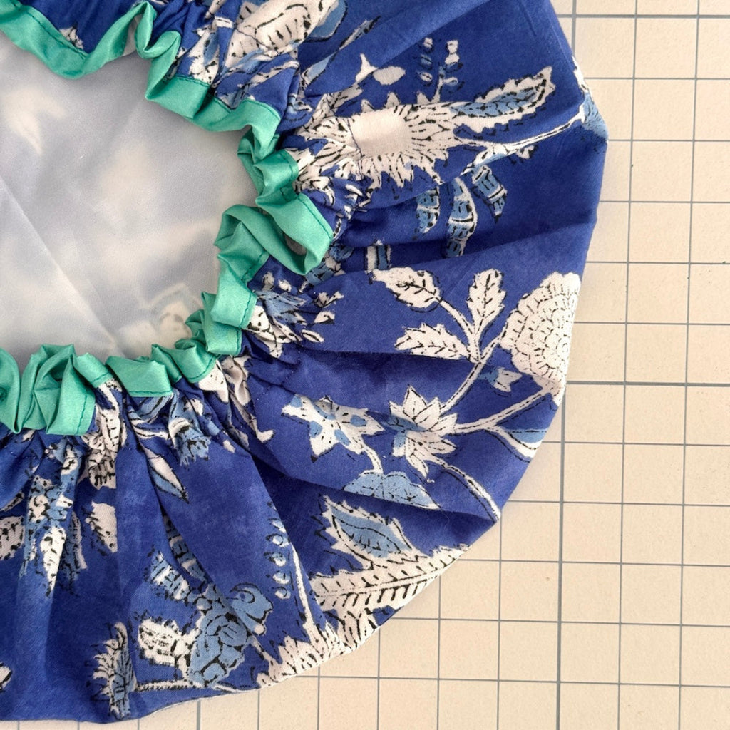 Close up of blue and white Oceania floral bat hat with turquoise trim.