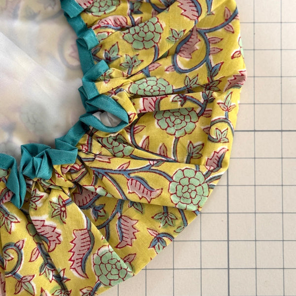 close up of yellow floral print Pearl bath hat with contrast trim