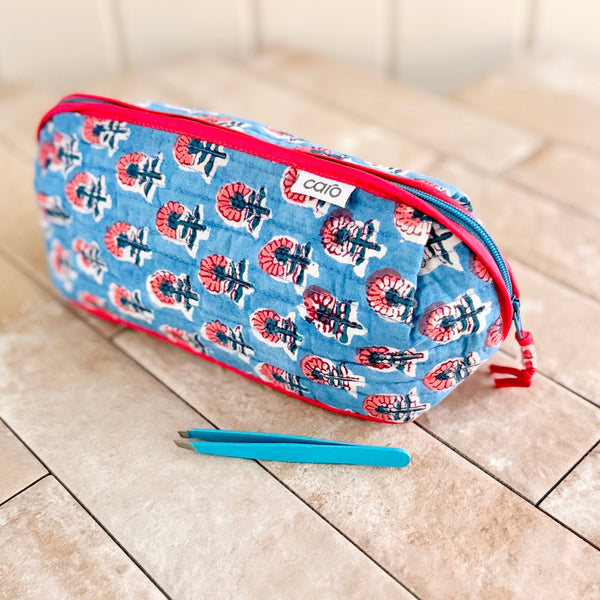 Make up bag with Caro label in blue and red small floral and red zip trim and tweezers