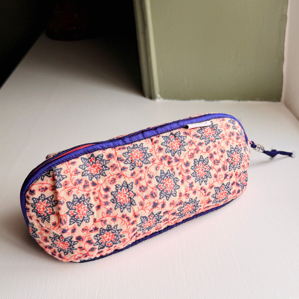 long, quilted make up bag in peach and blue floral print with dark blue trim