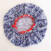 A round shower cap with a blue and white coral pattern, featuring a red elasticized inner trim and a white lining center panel, shown on a plain white background.