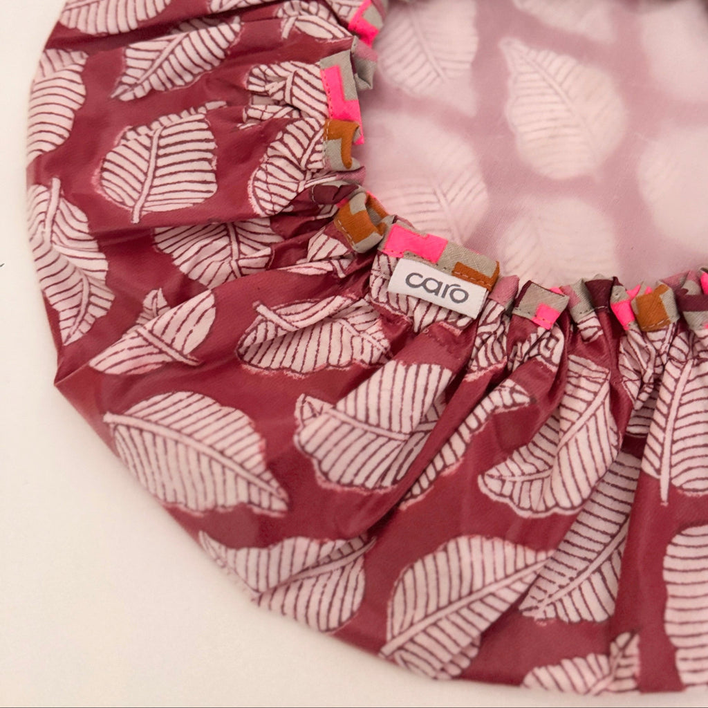 Close up of a Caro Shower cap made from red leaf motif print