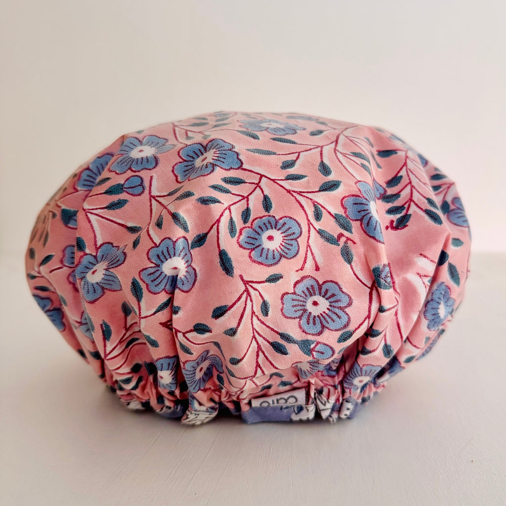 Shower Cap in pretty pink and blue floral pattern displayed on a light-colored surface 