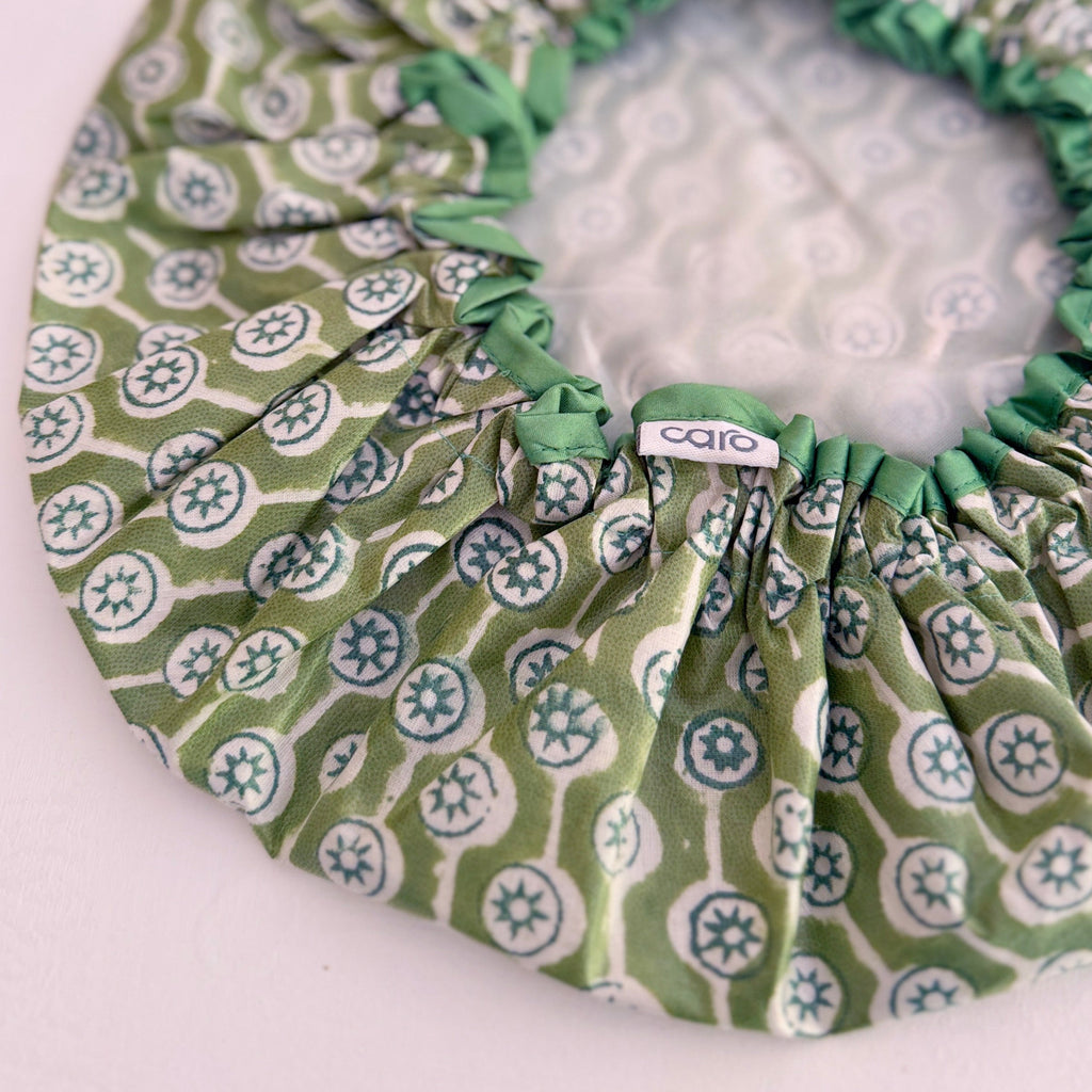 Close up of olive green and white geometric print waterproof shower cap.