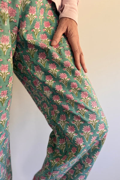 Floral patterned pants being worn on a plain background