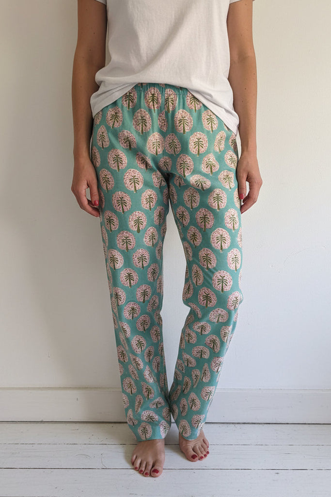 Green pajama pants with floral pattern worn by a woman.