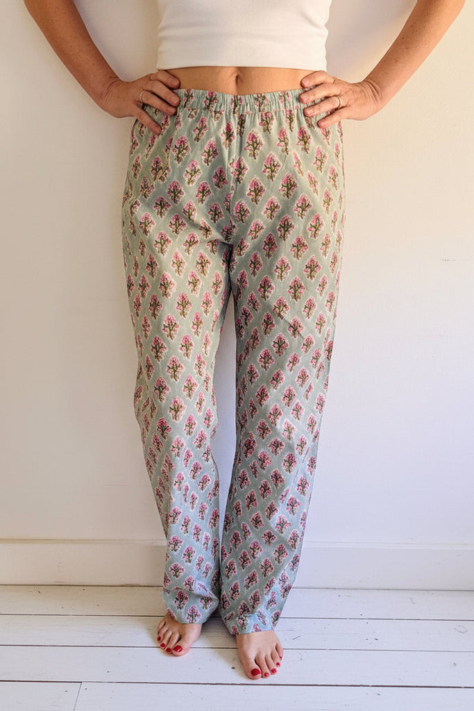 Person wearing floral pajama pants on a white background