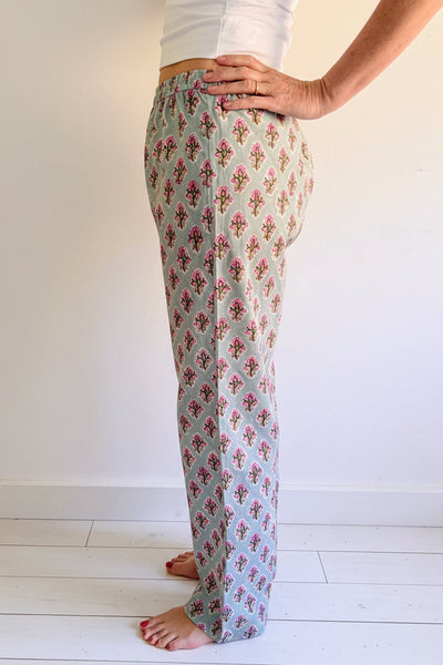 Person wearing floral-patterned pants on a white background
