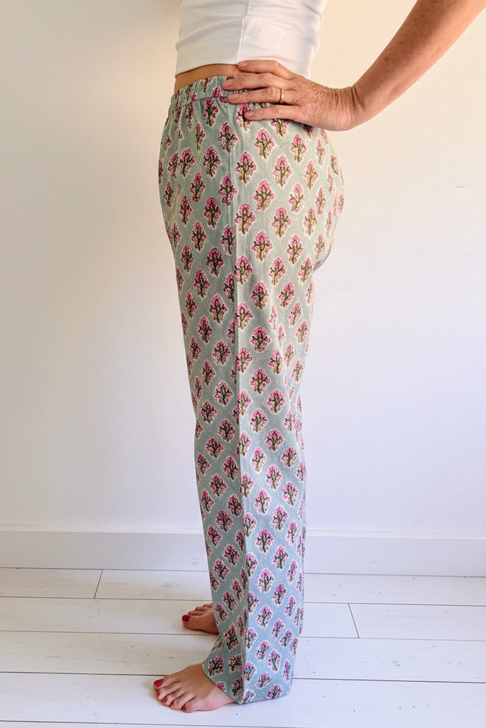 Person wearing floral-patterned pants on a white background