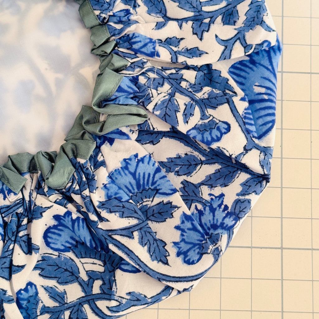 Close up of blue floral on white ground with soft grey blue trim