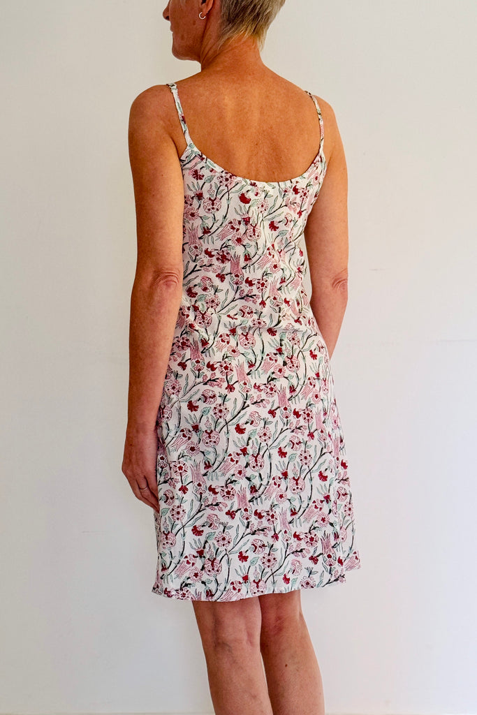 Woman wearing a floral dress against a plain background
