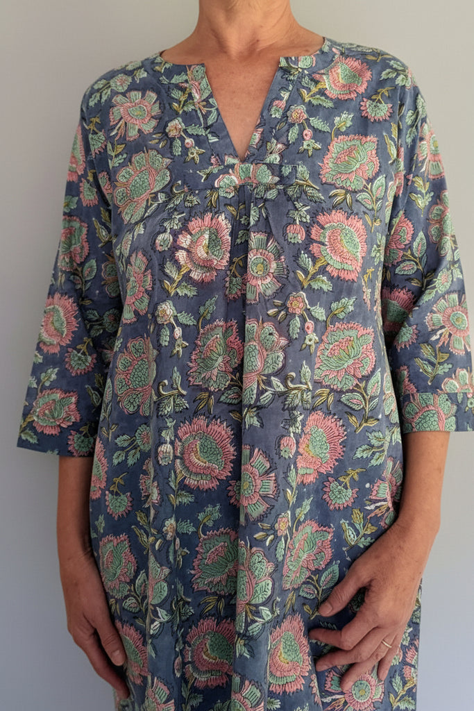 Floral patterned dress worn by a person on a white background
