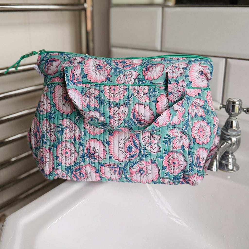 Turquoise and Pink floral washbag with handle on white basin