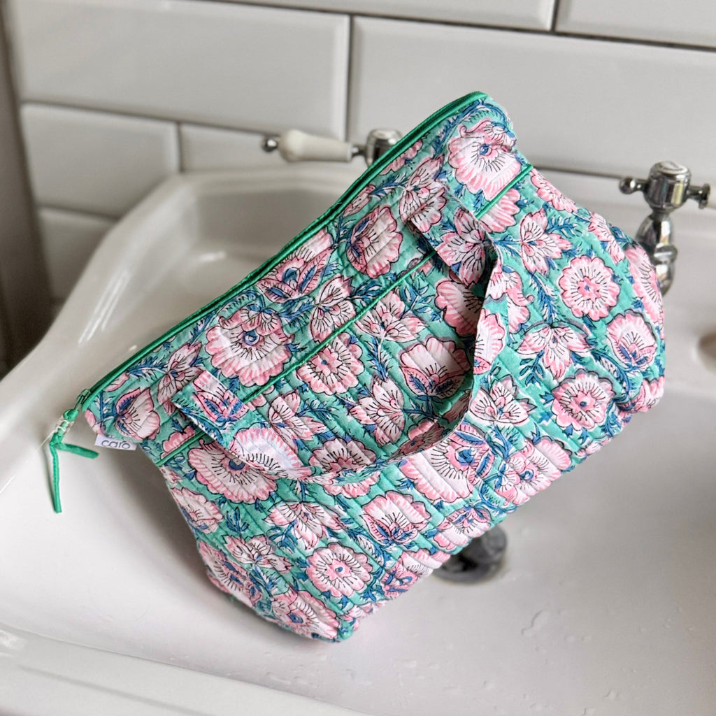 Turquoise and Pink floral washbag with handle on white basin