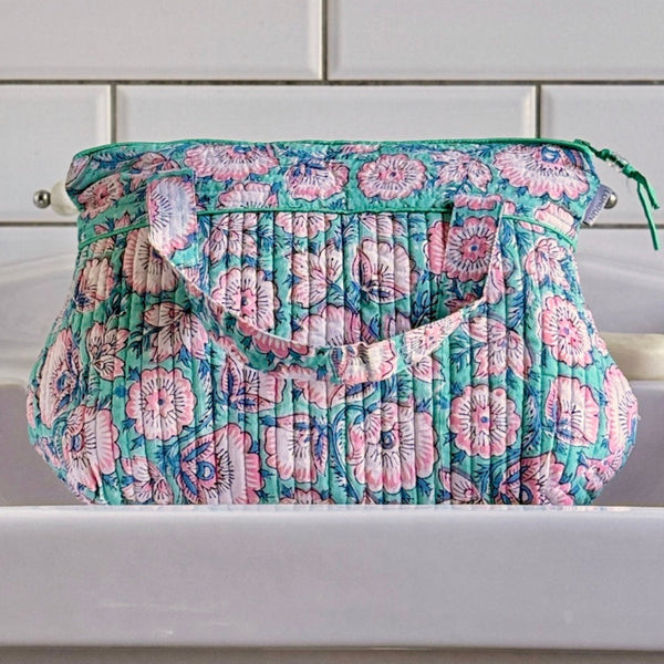 Turquoise and Pink floral washbag with handle on white basin