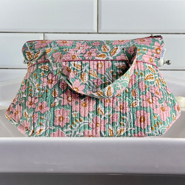 Green floral wash bag on white sink