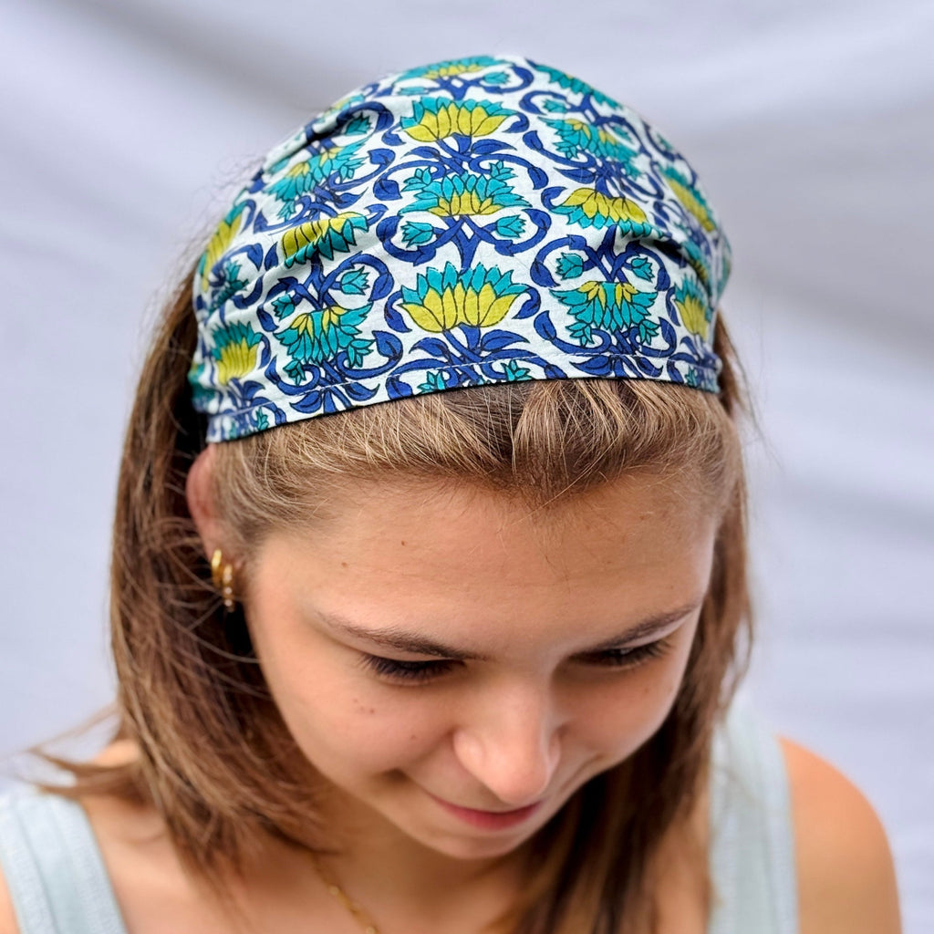 Woman wearing a colorful patterned headband against a plain background
