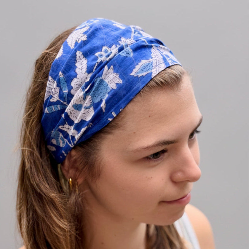 Woman wearing a blue floral headband with a natural background