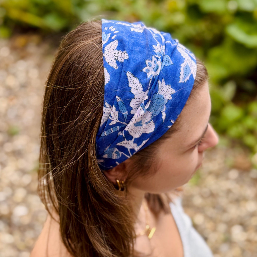 Woman wearing a blue floral headband with a natural background