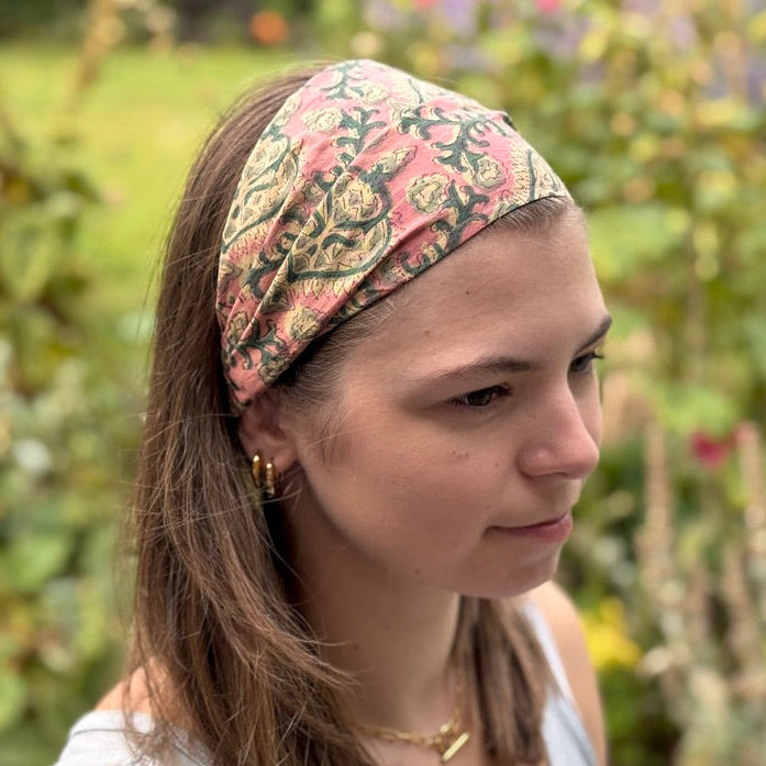 Woman wearing a patterned headband in a garden setting