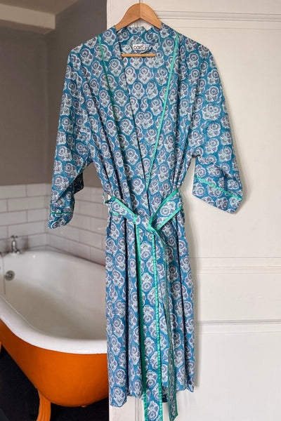 Blue patterned robe hanging in a bathroom with an orange bathtub.