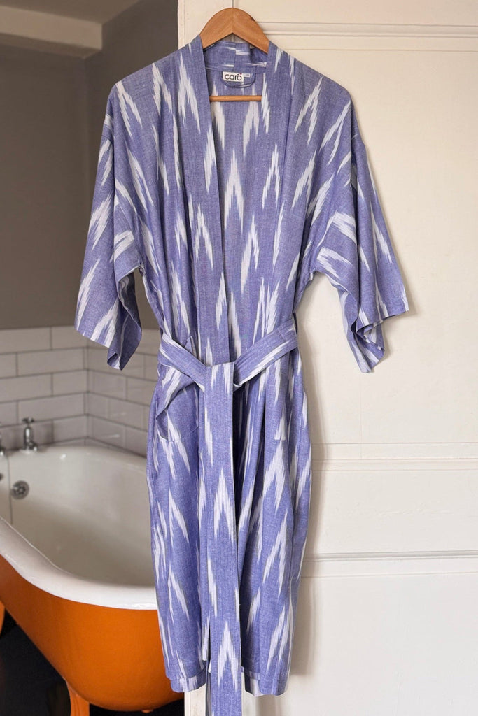 Blue and white patterned robe hanging on a hook in a bathroom.