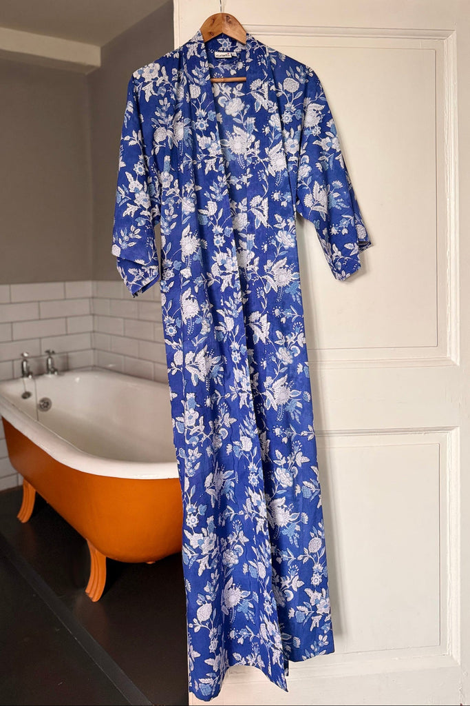 Blue floral robe hanging on a white door in a bathroom.