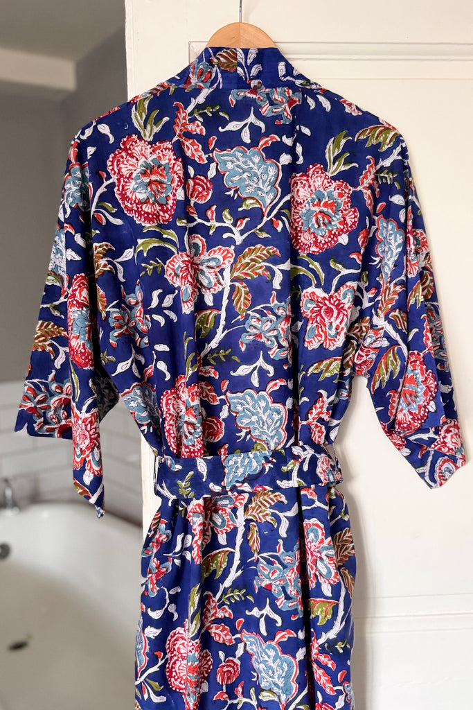 Floral patterned robe on a hanger against a white background