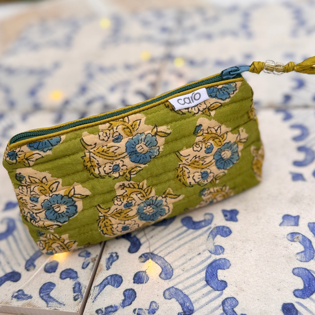 Floral-patterned pouch with a visible brand label on a textured surface