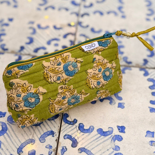 Green floral-patterned pouch on a blue and white patterned surface