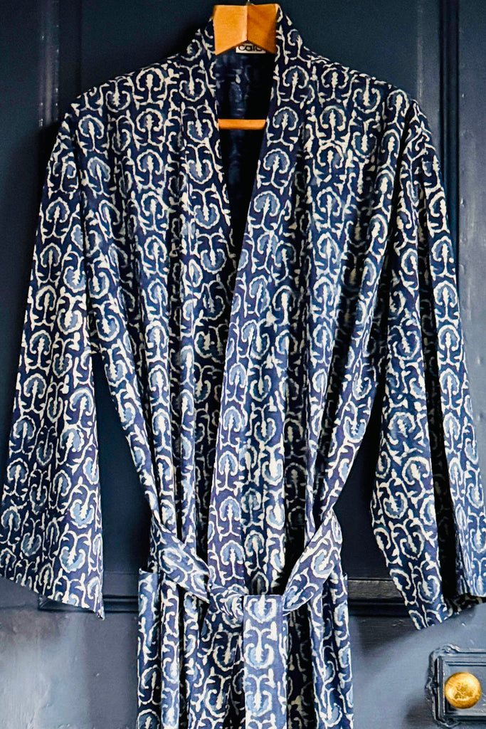 Patterned robe hanging on a hook against a dark background