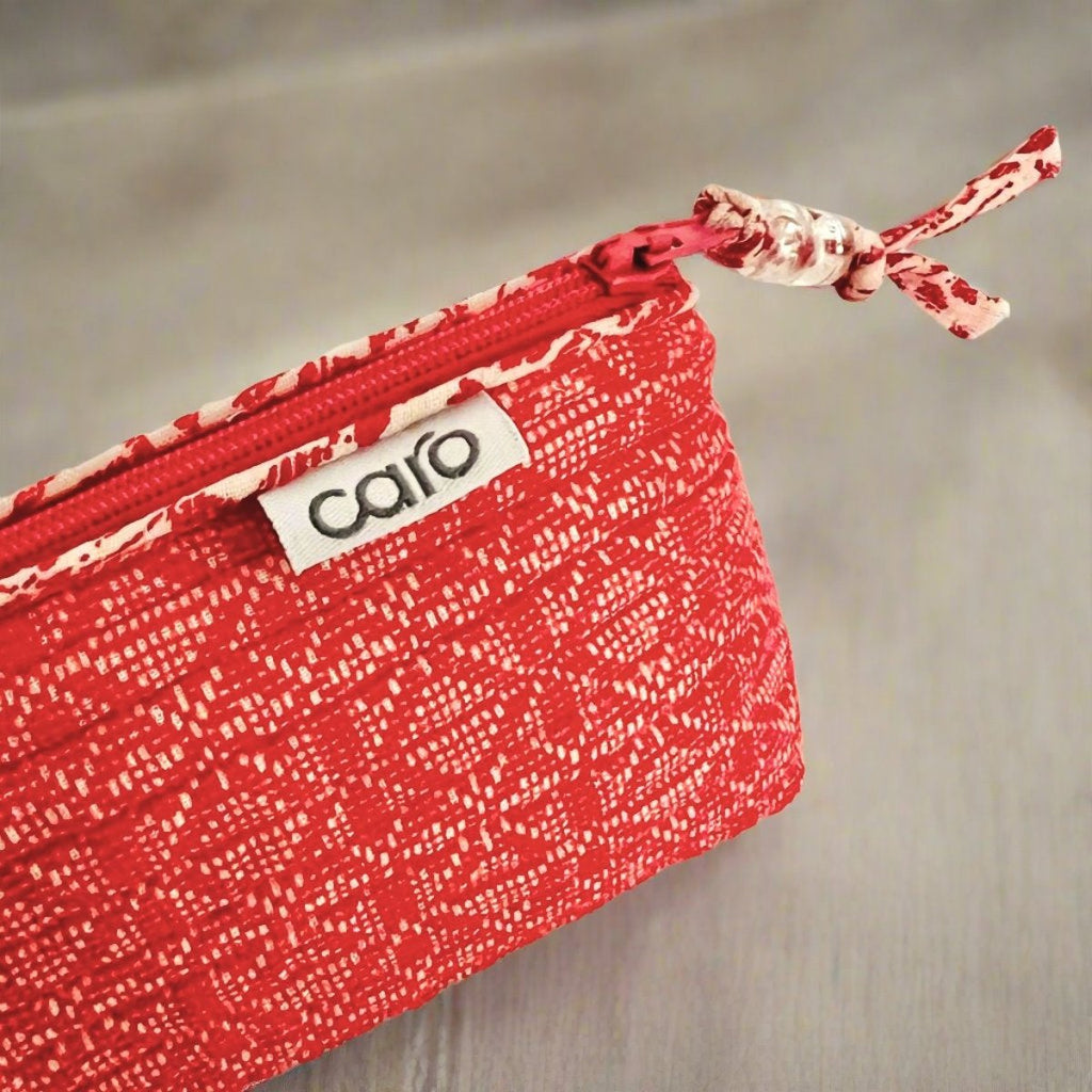 small red make up bag close up of label and trim