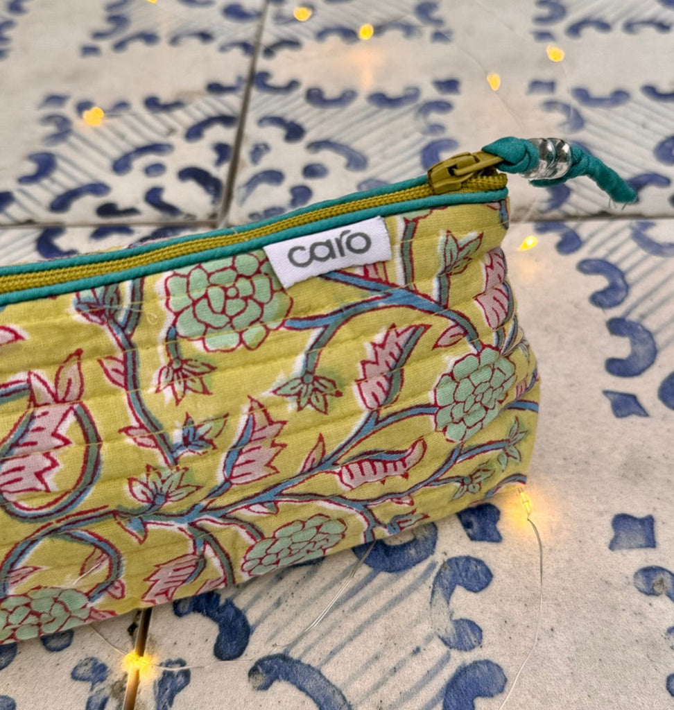 Floral-patterned pouch with 'caro' branding on a textured surface