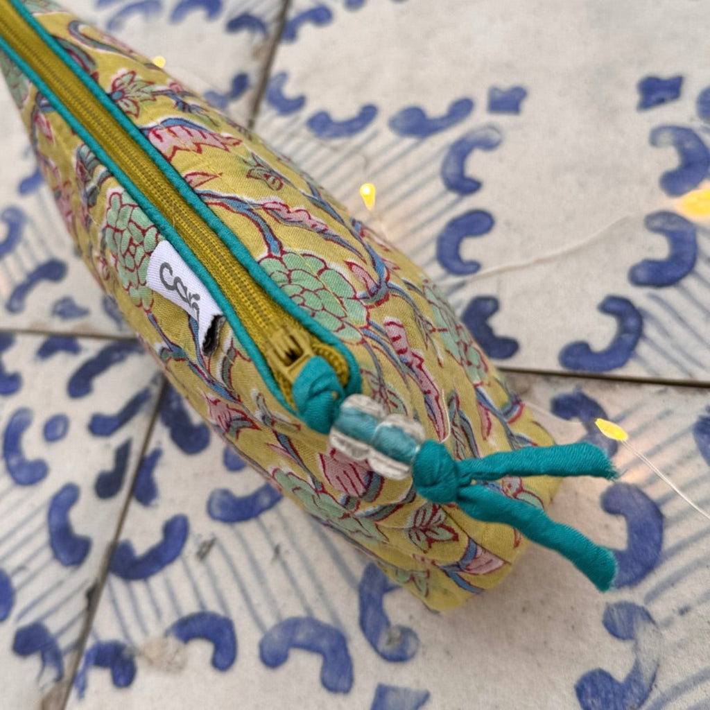 Colorful fabric pouch with a zipper on a patterned tile background