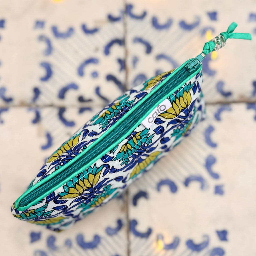 Floral-patterned pencil case with a green zipper on a tiled wall background
