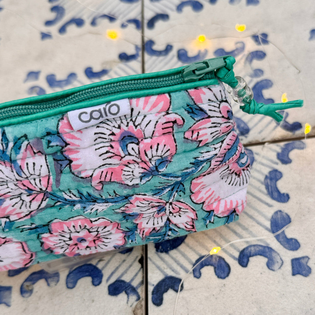 Floral patterned pouch with green zipper on a textured surface