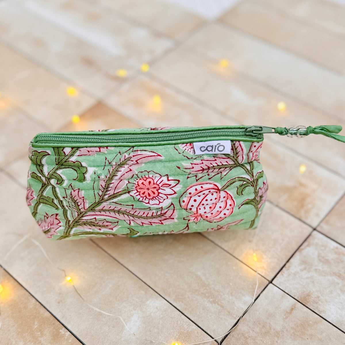 green floral cosmetic bag on beige tiles