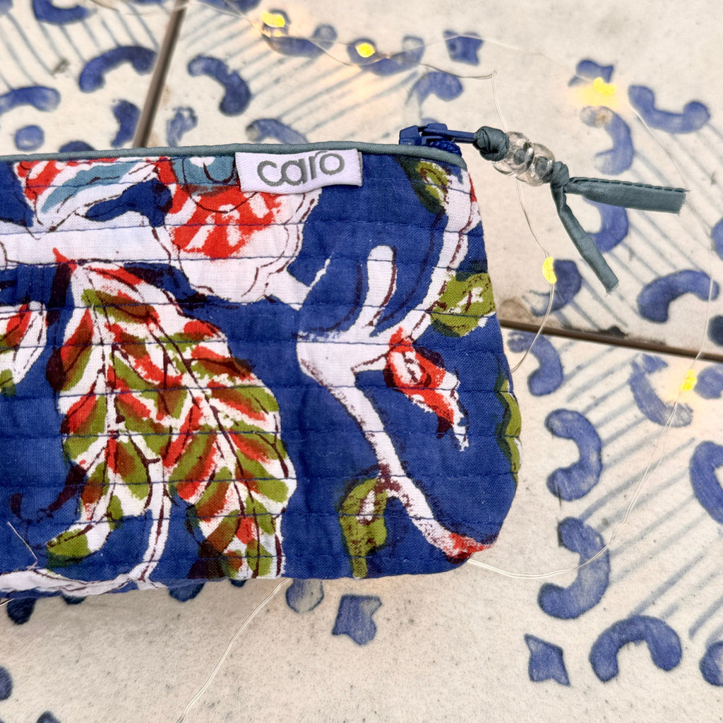 Floral-patterned pouch with 'calia' branding on a textured surface
