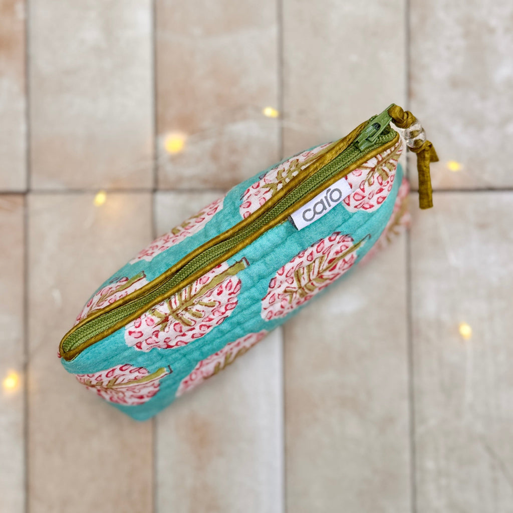 Floral patterned pencil case with green zipper on a tiled background