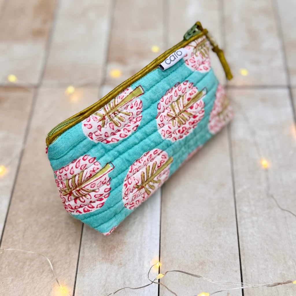Floral patterned pouch on a tiled surface with string lights