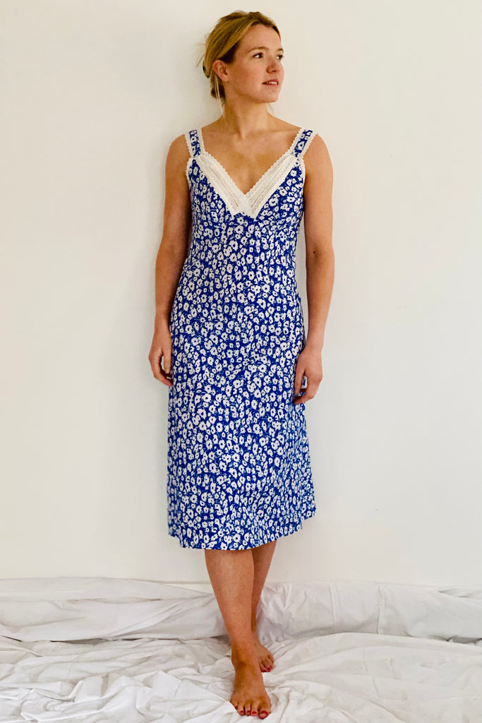 Semi fitted adjustable strapped nightdress with just below the knee length and V necked lace trim in blue and white floral by caro london
