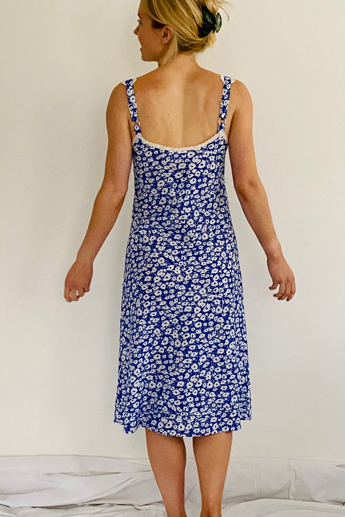 Semi fitted adjustable strapped nightdress with just below the knee length and V necked lace trim in blue and white floral by caro london