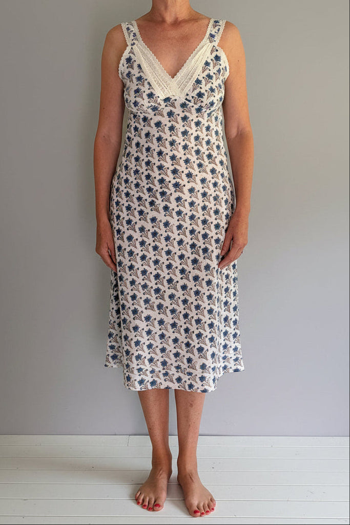 Woman wearing a floral dress against a plain background